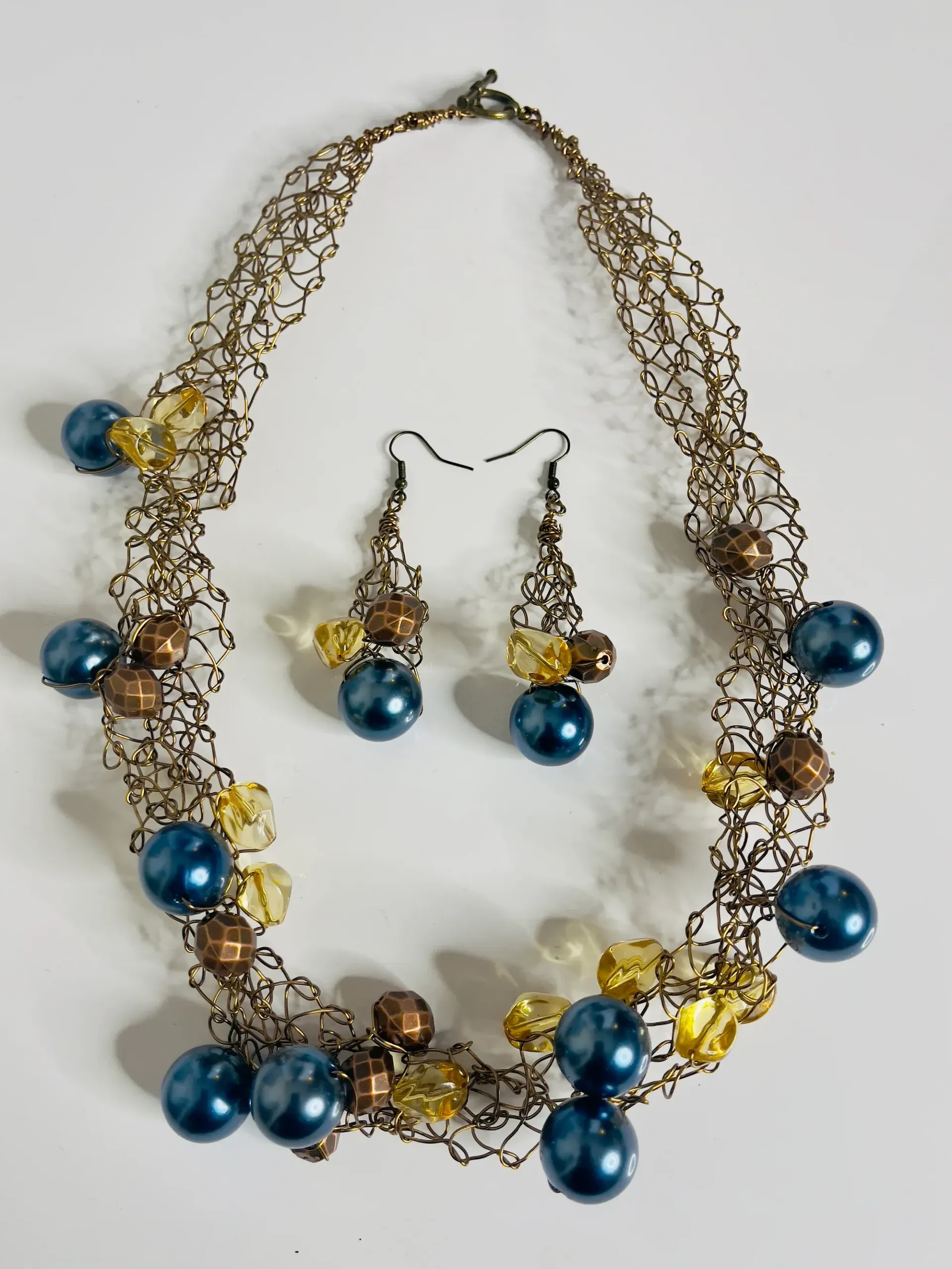 Necklace and earrings set: Bronze-toned chain with blue and yellow beads.
