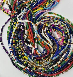 Colorful beaded waist beads in a tangled pile.