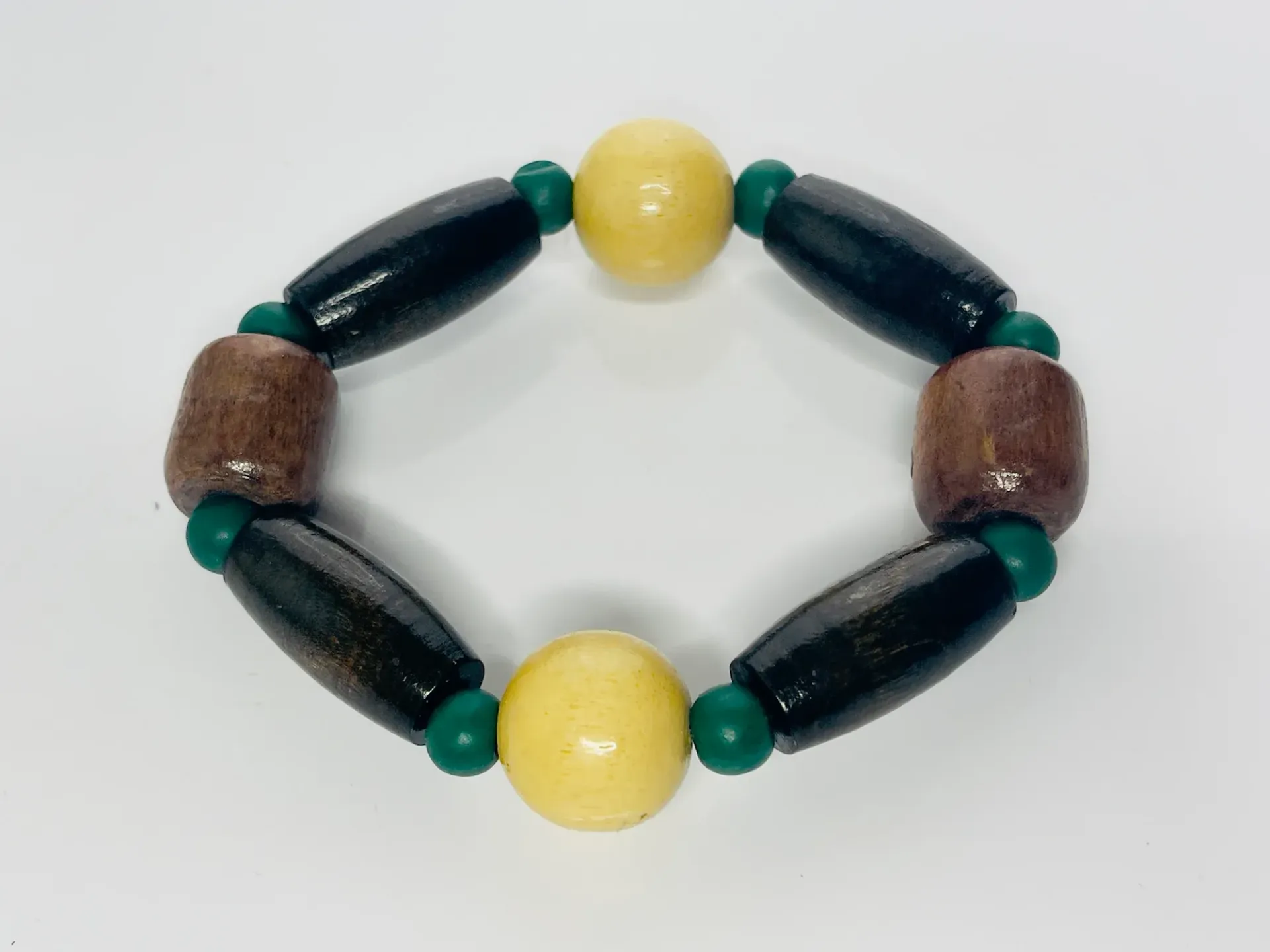 Bracelet with brown, black, and yellow beads separated by small green beads.