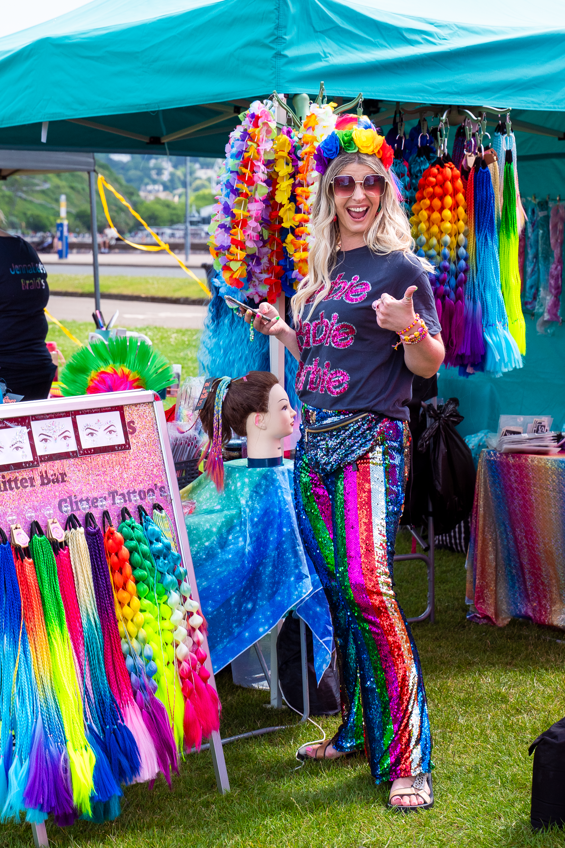 a lady brading hair with raibow atire