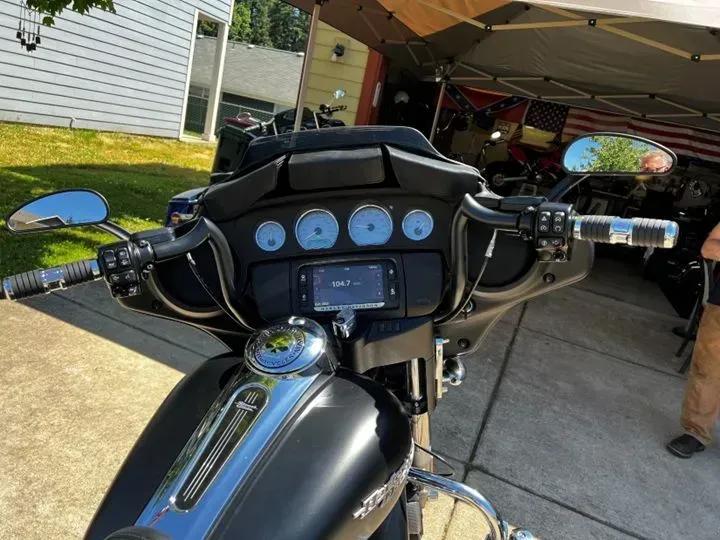 A black harley davidson motorcycle is parked in a driveway