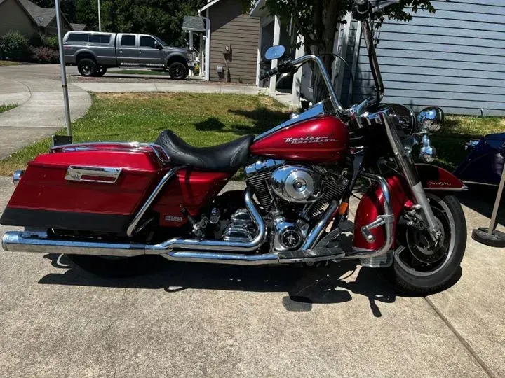 A red harley davidson motorcycle is parked on the sidewalk