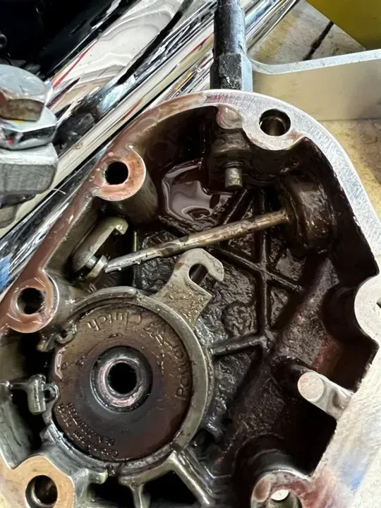 A close up of a motorcycle engine with a screw in it.
