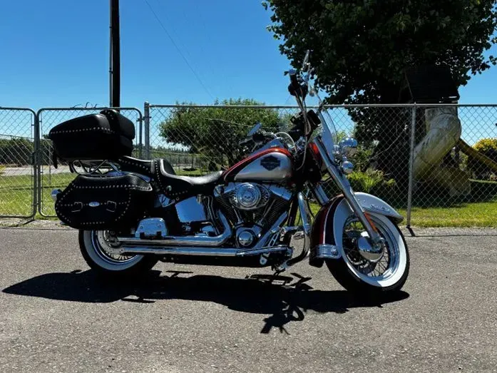A harley davidson motorcycle is parked in front of a chain link fence