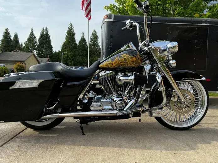 A black harley davidson motorcycle is parked in front of a trailer.