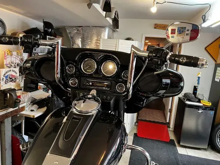 A black harley davidson motorcycle is parked in a garage.