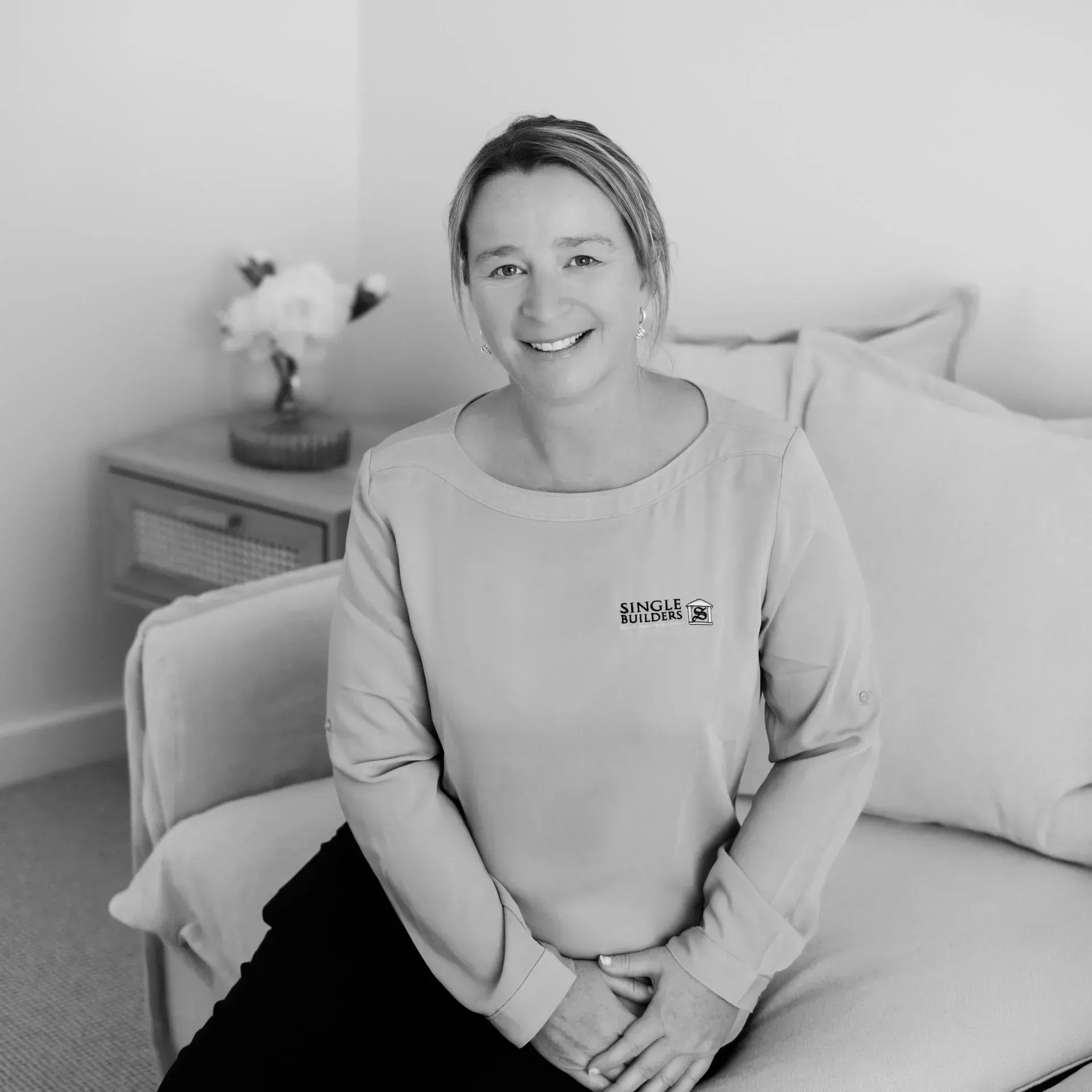 A black and white photo of a woman sitting on a couch