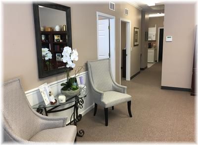 Quiet interior reception space with seating, tasteful decor, and corridor in a modern cremation service facility

