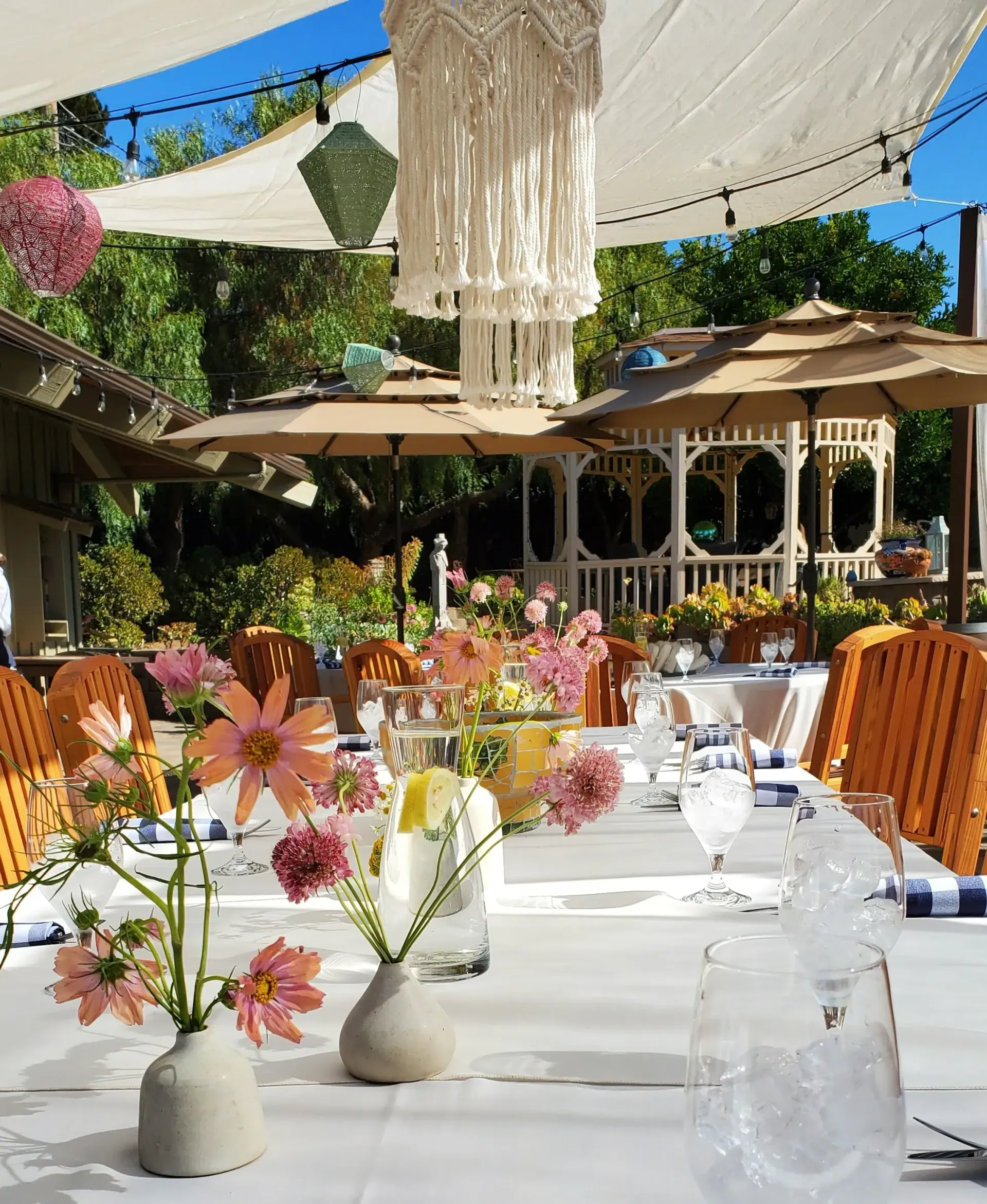 A table set for a wedding reception with flowers in vases