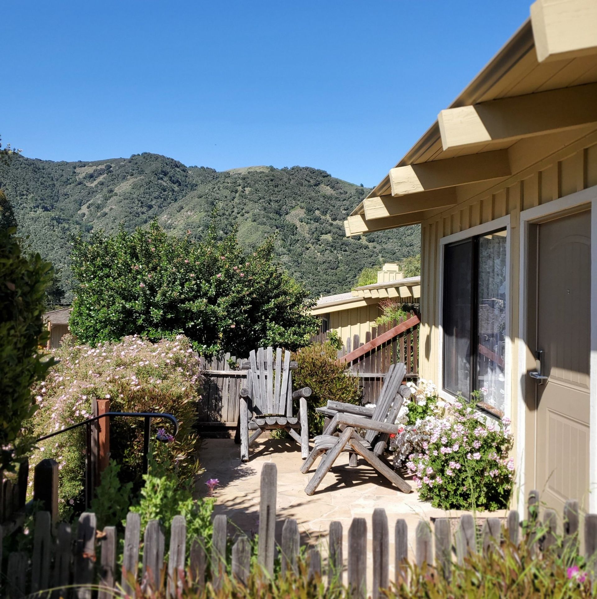 A house with a fence and chairs in front of it