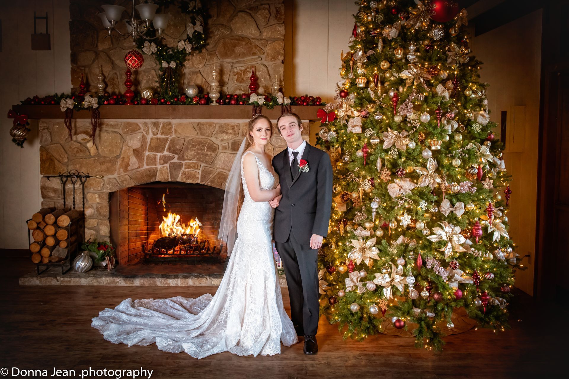 A bride and groom are posing for a picture in front of a christmas tree.