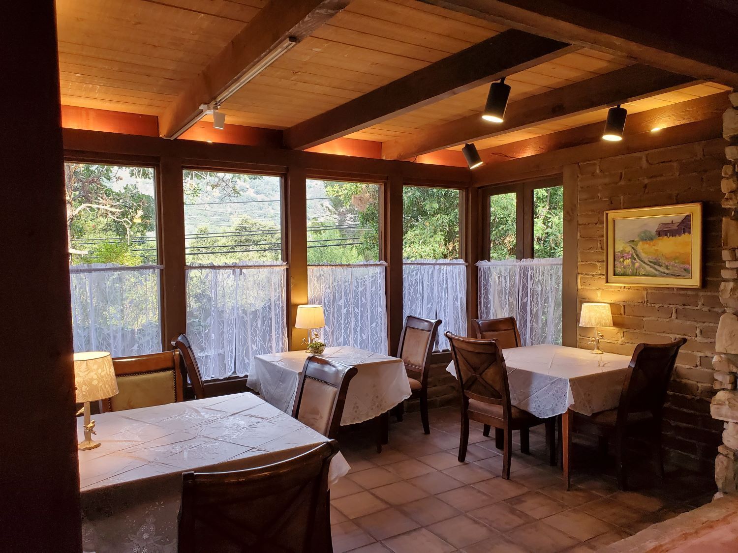 A restaurant with tables and chairs and a painting on the wall.