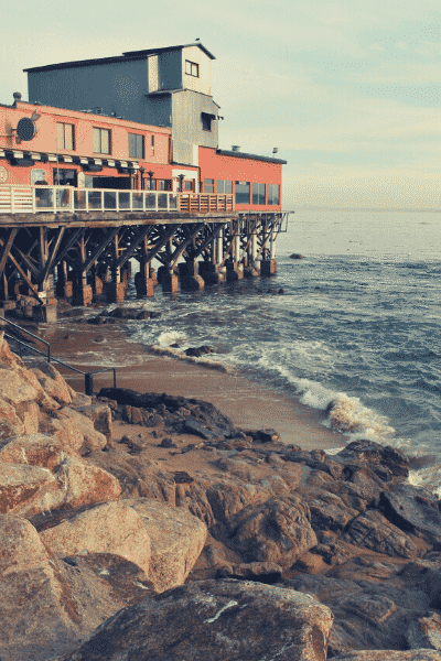 A large building on a pier overlooking the ocean