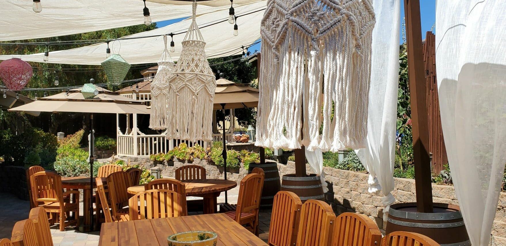 A patio with tables and chairs under a canopy.
