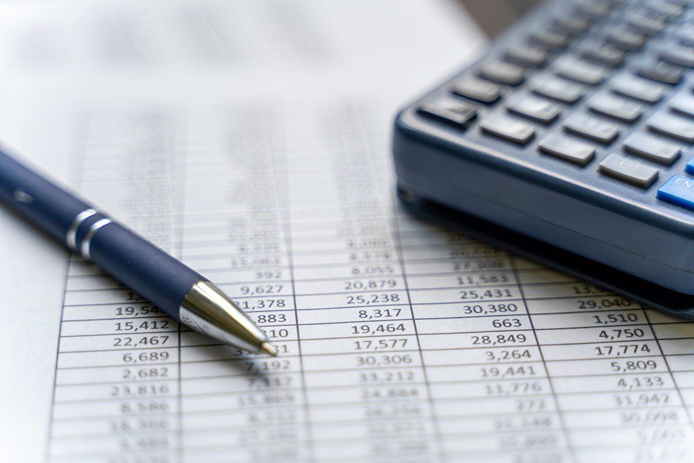 Accounting Table With Pen And Calculator — Chattanooga, TN — Houston & Alexander, PLLC