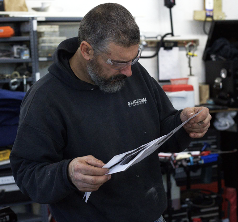A person is working on a boat engine with a wrench.