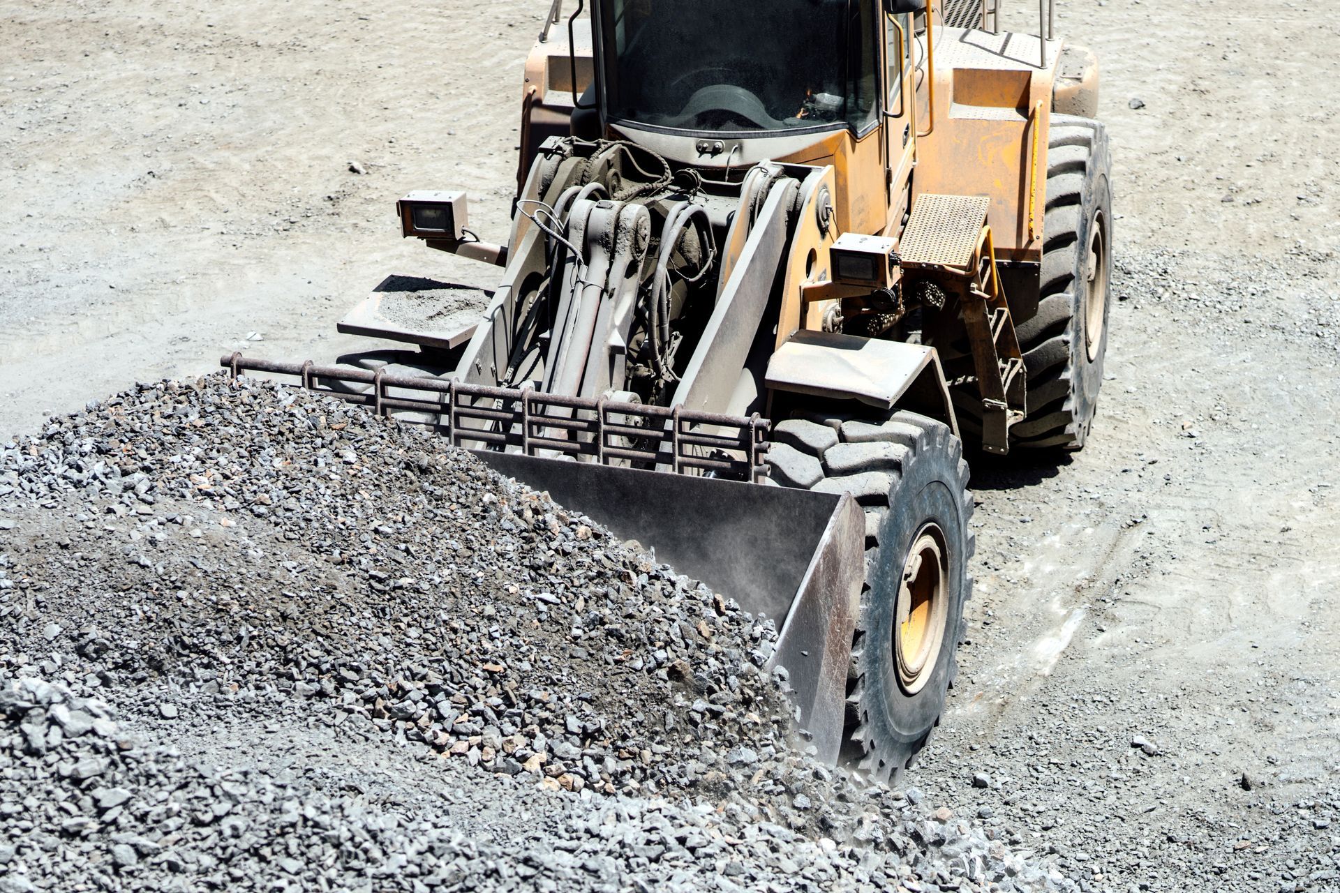 Heavy duty large wheel loader loading gravel at work site. Heavy duty large wheel loader loading gravel at work site.