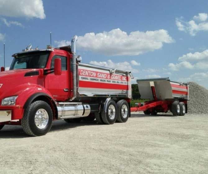 Denton Sand & Gravel truck in front of a pile of rock.