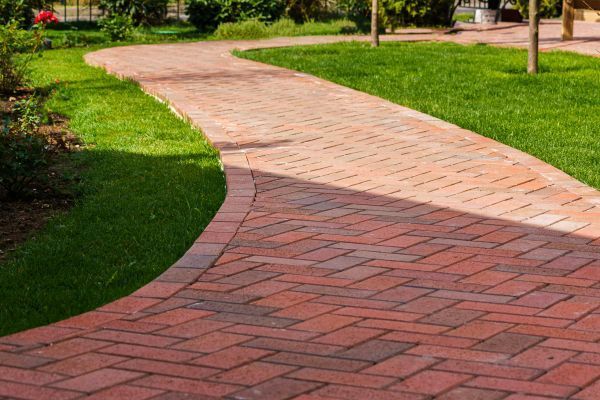 Brick pathway winding through green grass.