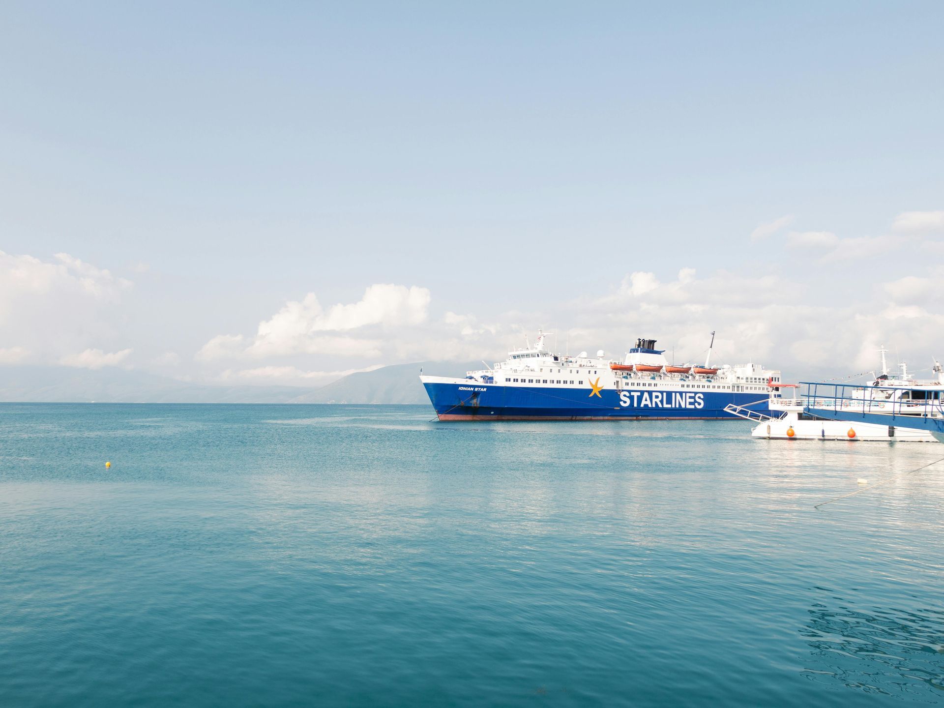 A blue and white ship is floating on top of a body of water.