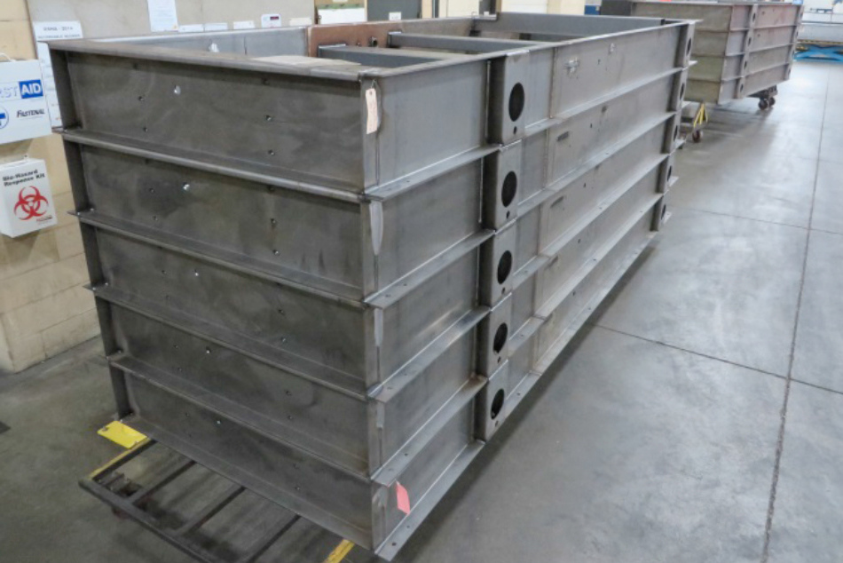 Tall stack of industrial steel skids illustrating high-capacity manufacturing for machinery mounting.