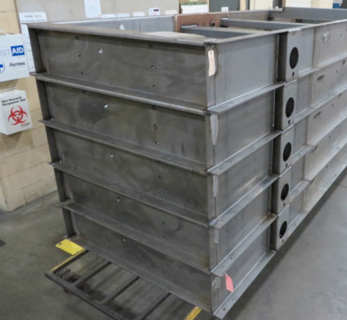 Tall stack of industrial steel base frames illustrating high-capacity manufacturing volume.