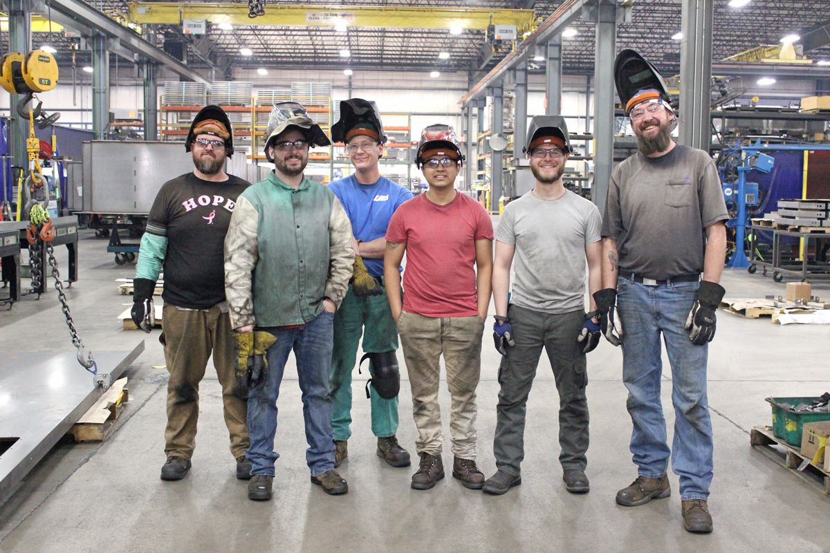 United Alloy welders smiling in their helmet.
