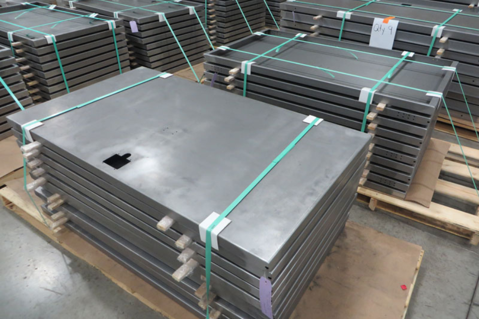Neatly stacked sheet metal sub-assemblies banded and palletized for high-capacity freight shipping.