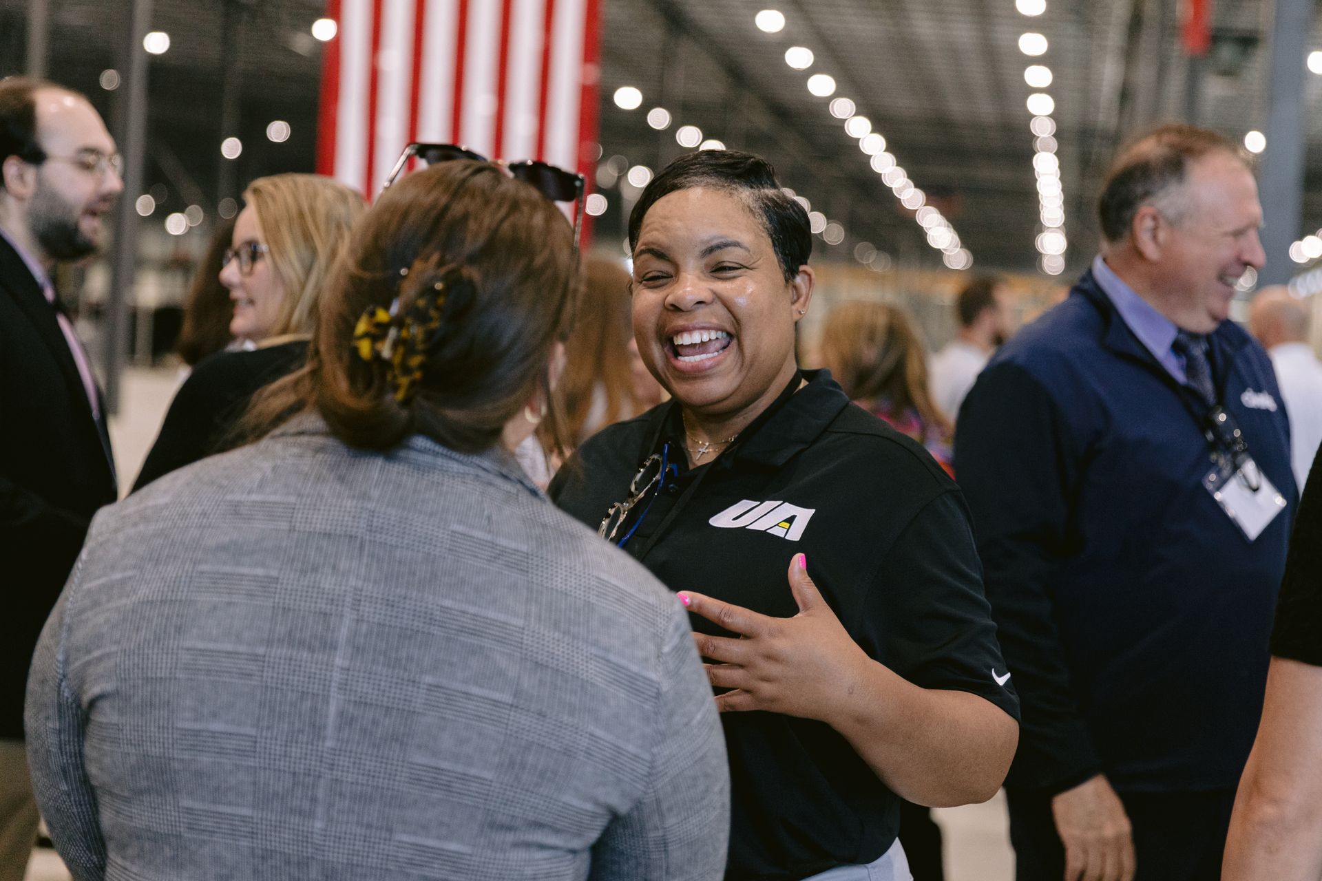 Corporate team members networking during the opening of a new industrial manufacturing facility.