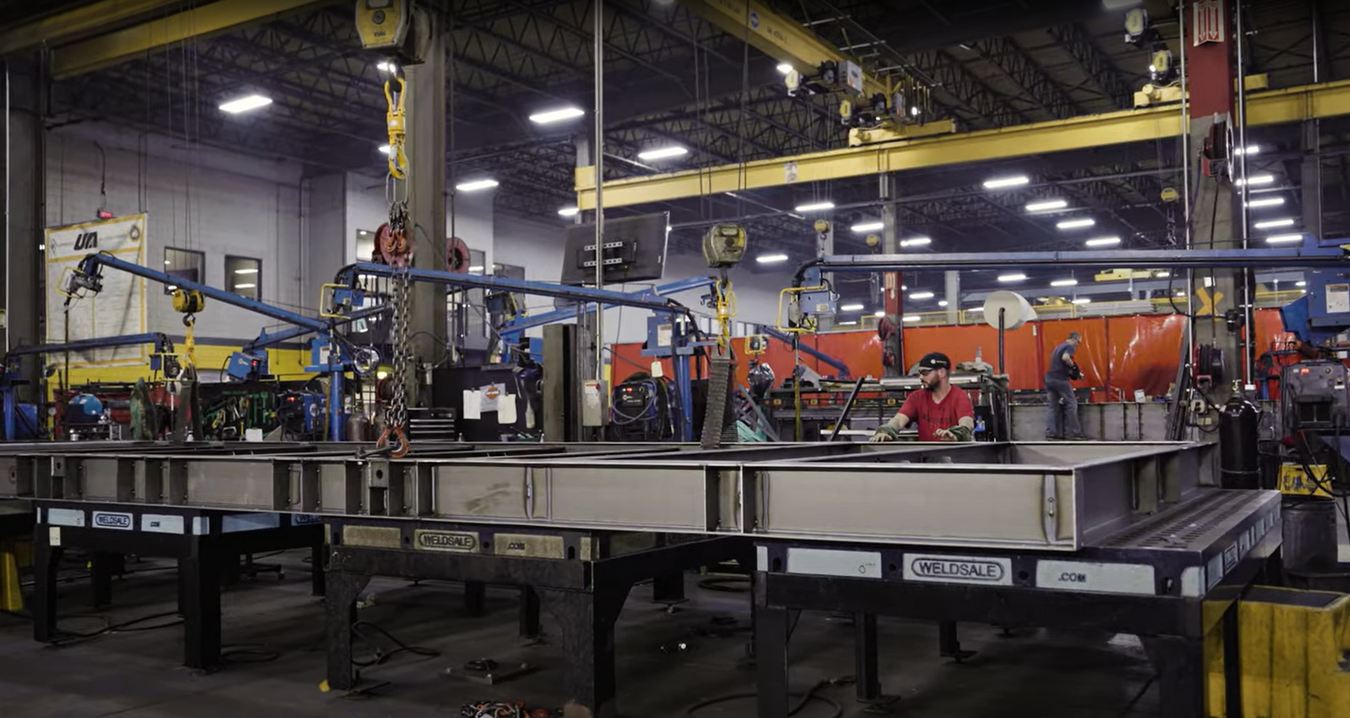 Wide-angle view of a United Alloy fabrication bay with heavy-duty overhead cranes and long-span steel frames.