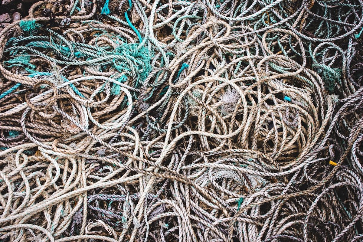 A bunch of ropes are stacked on top of each other on the ground.