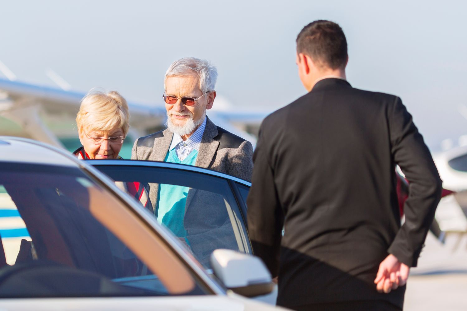 A man and a woman are getting out of a car.