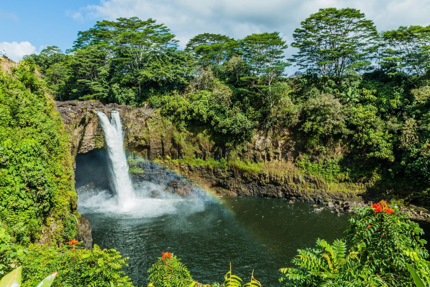 A waterfall with a rainbow in the middle of it