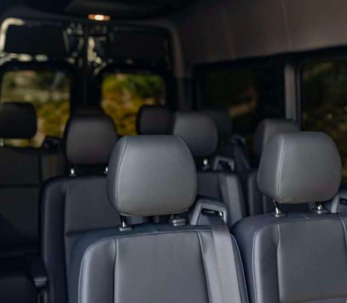 The interior of a van with a lot of seats and headrests.