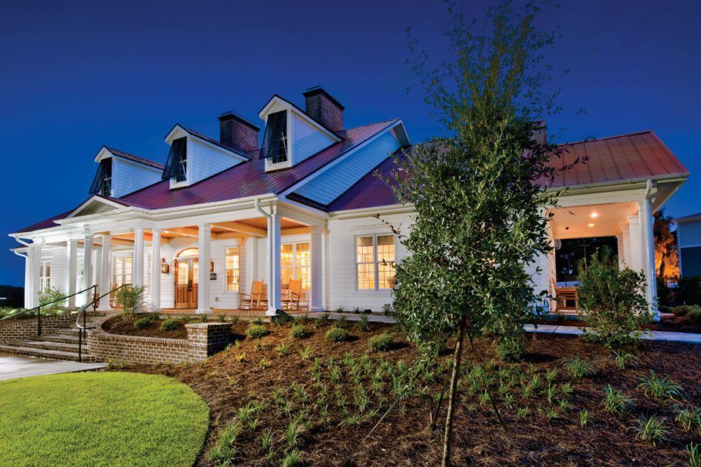 A large white house with a red roof is lit up at night at Grand Oaks at Ogeechee River in Savannah, GA.