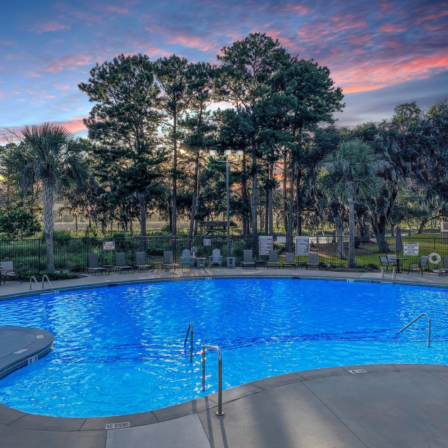 A large swimming pool with trees in the background at Grand Oaks at Ogeechee River in Savannah, GA.