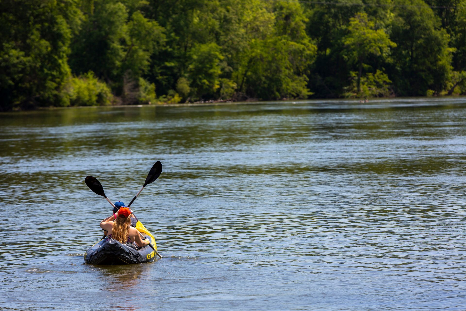 A person is paddling a kayak on a river at Grand Oaks at Ogeechee River in GA