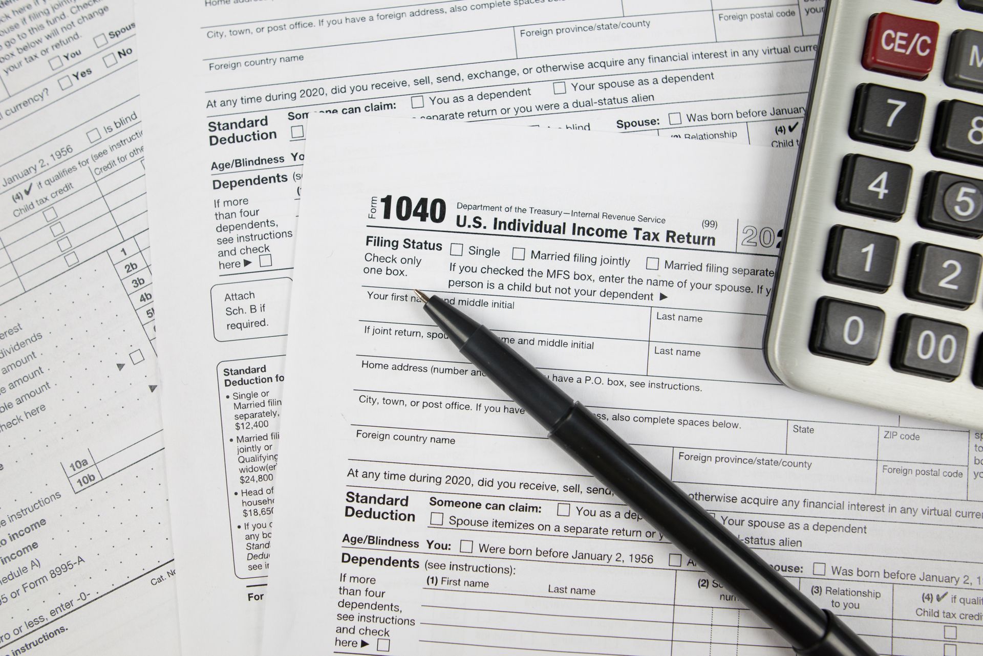 Tax forms with a calculator and pen.