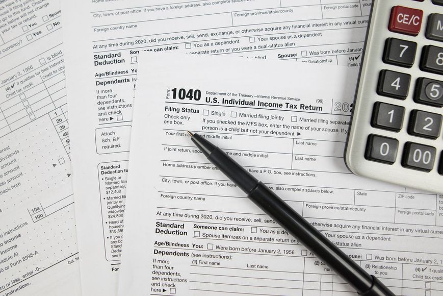 Tax forms with a calculator and pen.