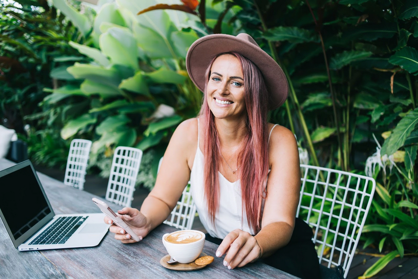 A local web designer based in Australia working on a laptop in a sunny outdoor café.
