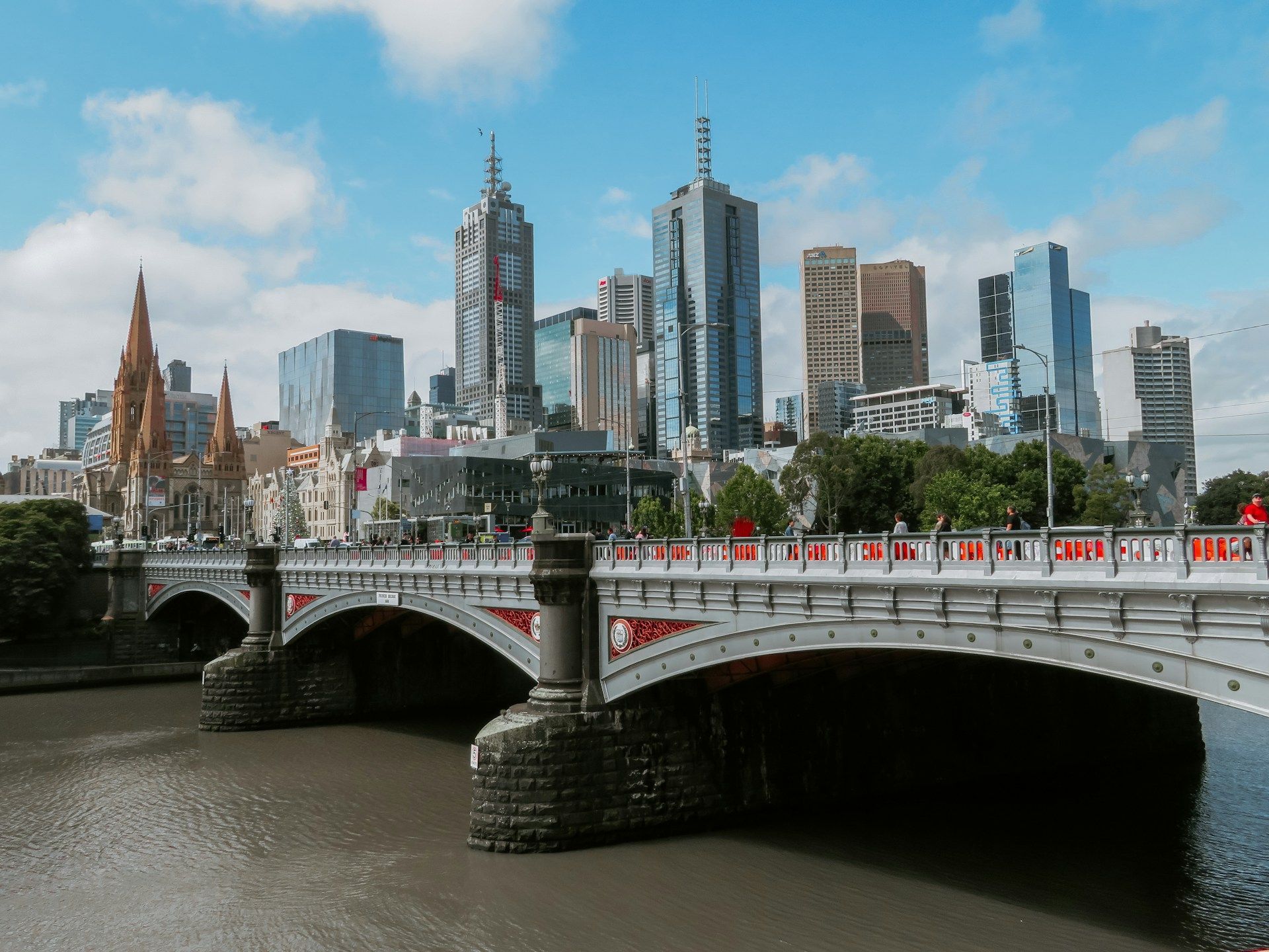 Melbourne bridge over a river with its city skyline in the background.