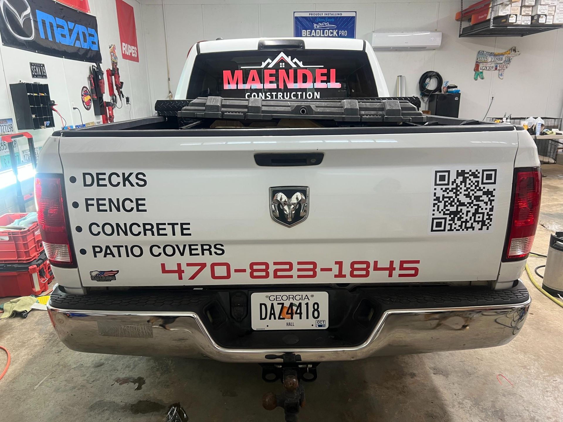 White Ram truck with business services listed on the tailgate, including a phone number and a QR code.