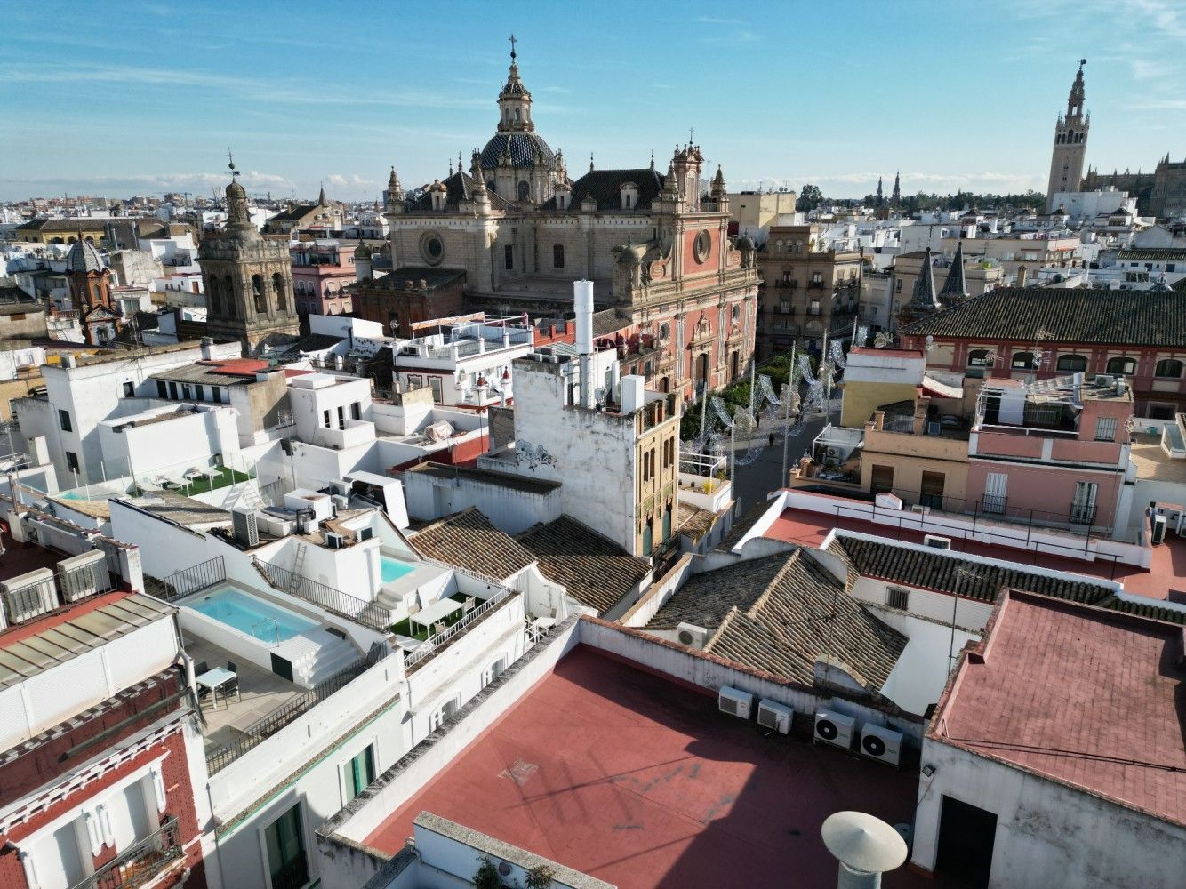 Vista aérea del horizonte de una ciudad histórica con tejados blancos y torres de catedrales bajo un cielo despejado.