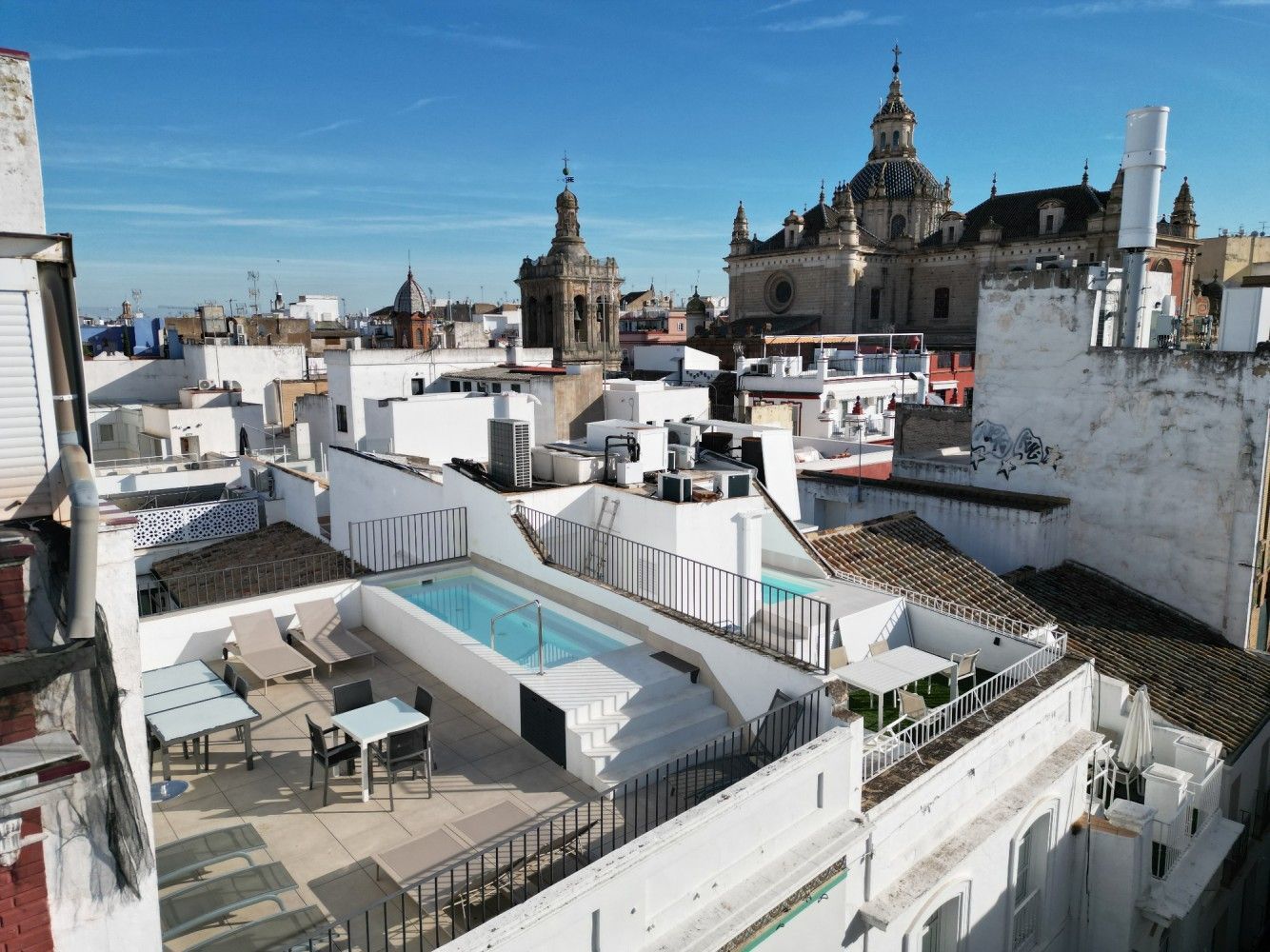 Vista desde la terraza de la azotea del horizonte histórico de la ciudad, con edificios blancos y torres de catedrales.