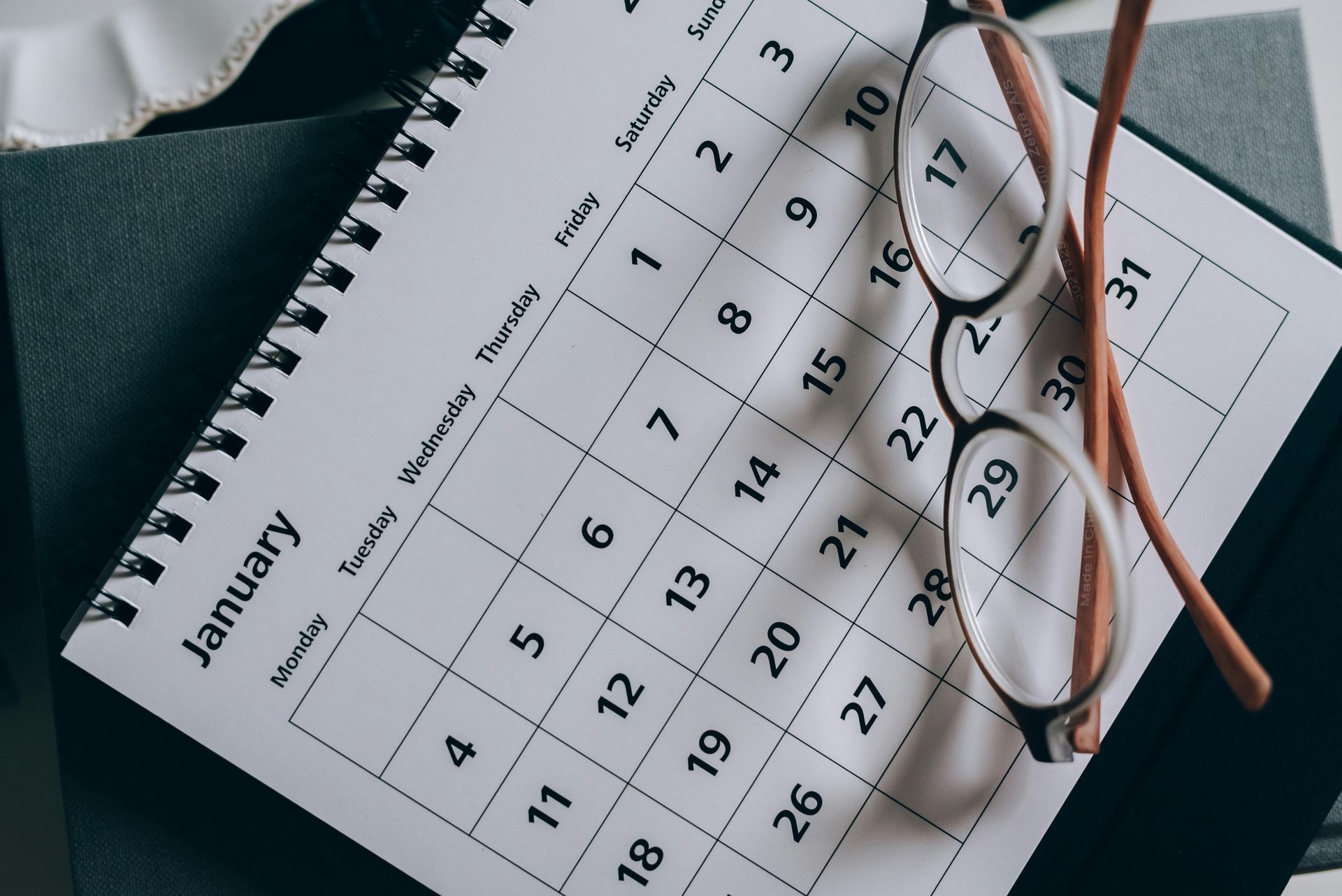 Calendar page for January with eyeglasses resting on it.