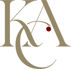 Stylized gold monogram letters with a small red dot on a white background