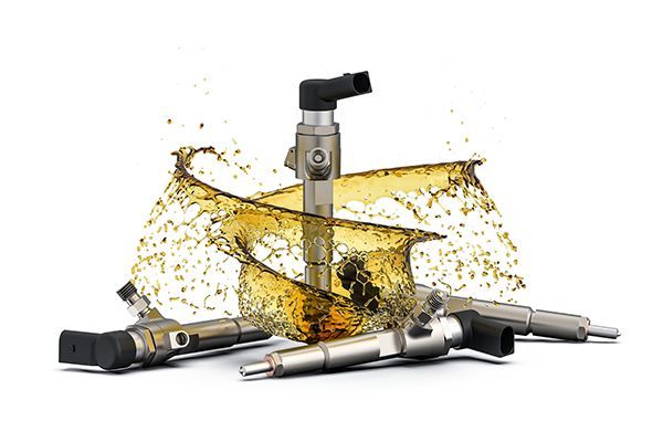 Fuel injectors with a splash of liquid, likely fuel or oil, against a white background.