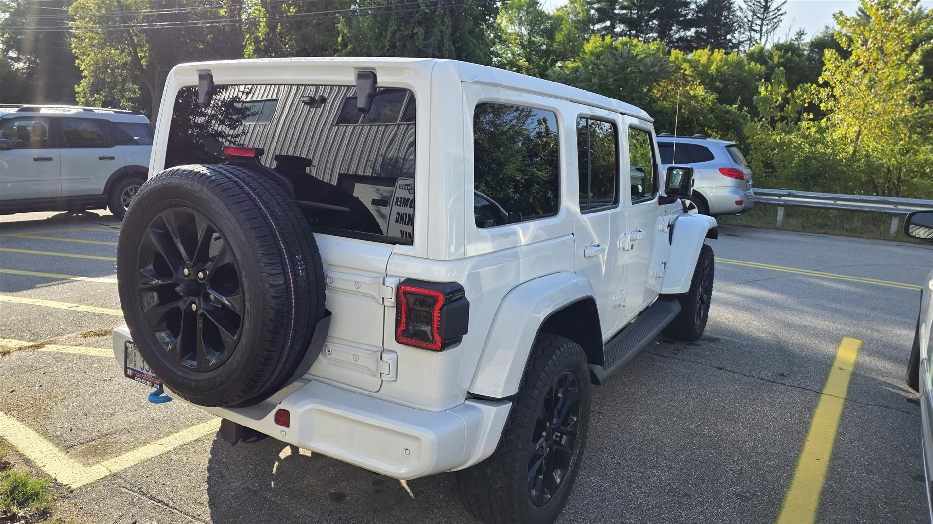 White Jeep SUV parked outdoors with spare tire.