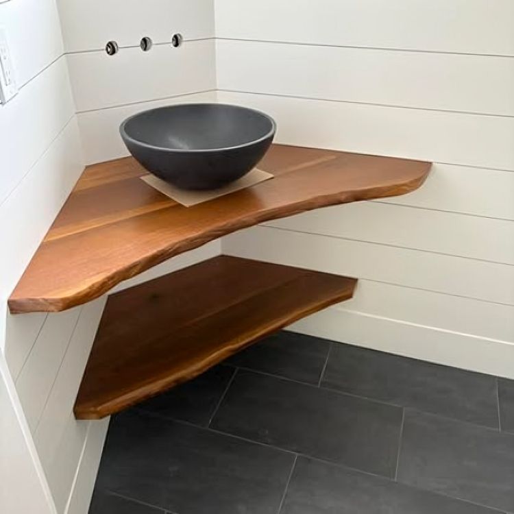 Corner bathroom shelves with a dark vessel sink on top.