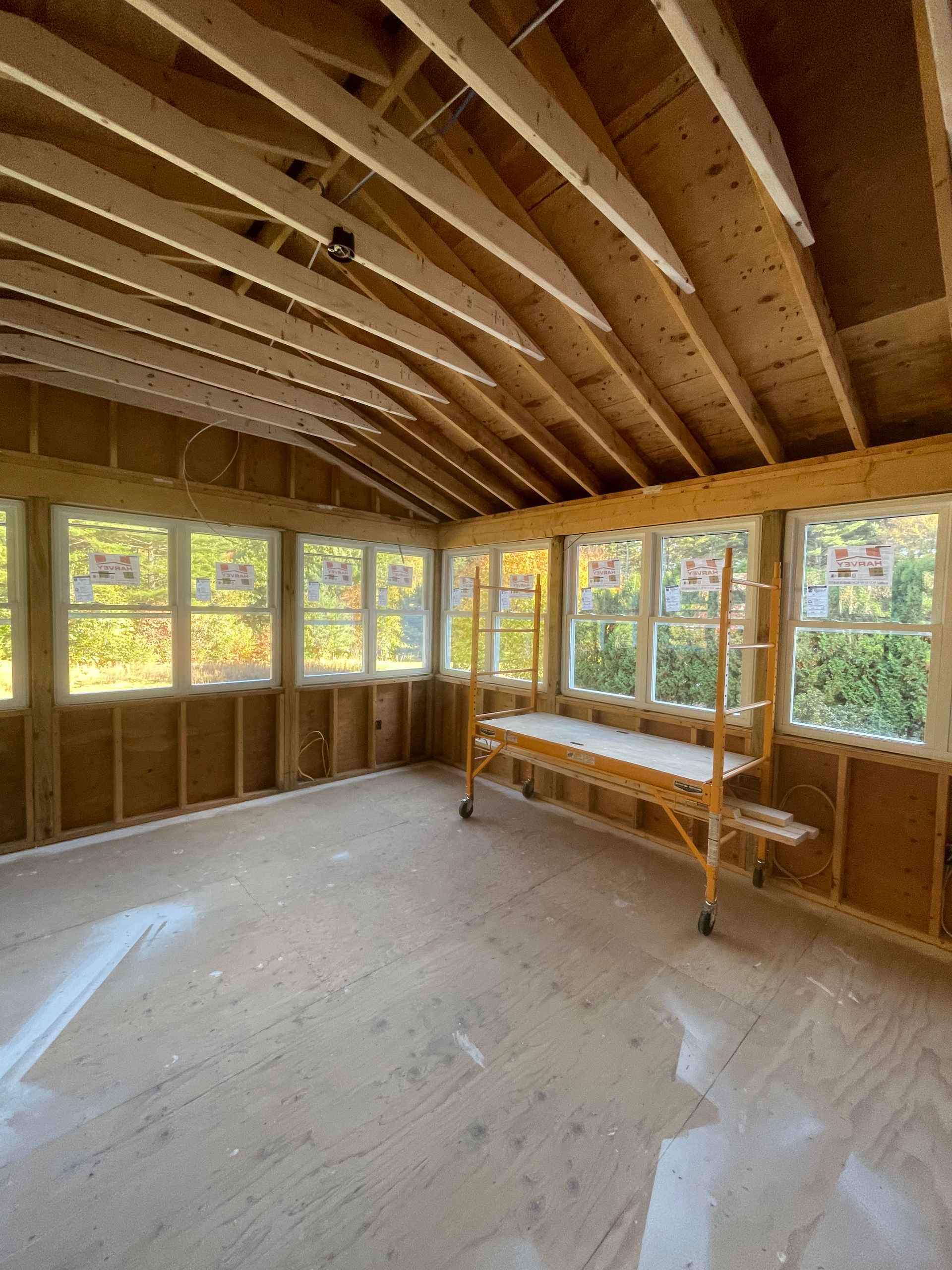 An empty room with a wooden table and scaffolding in it.